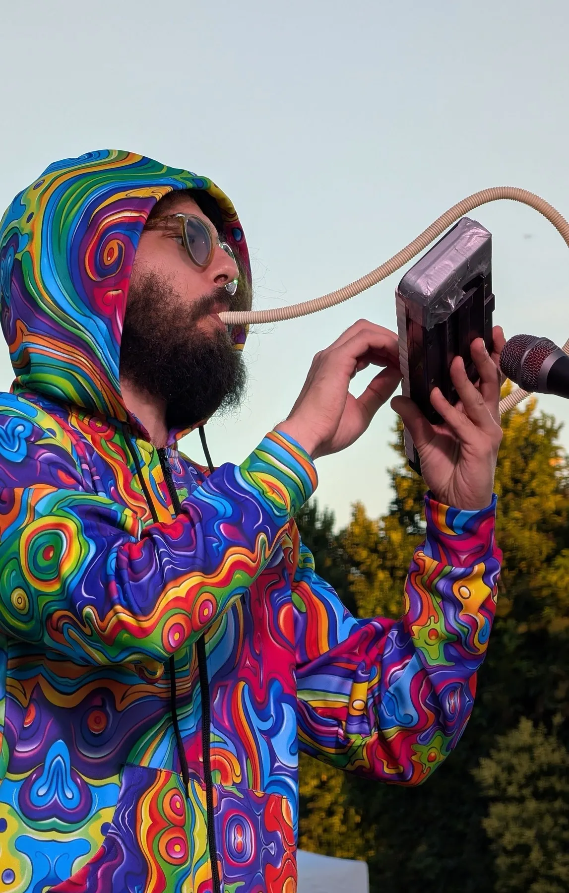 Silvestro nel Cosmo playing a melodica in the colourful suit, live outdoors.